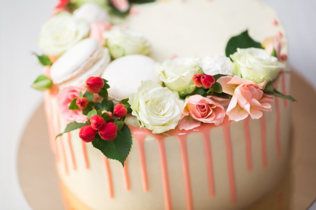 Cake with fresh flowers and macaroons