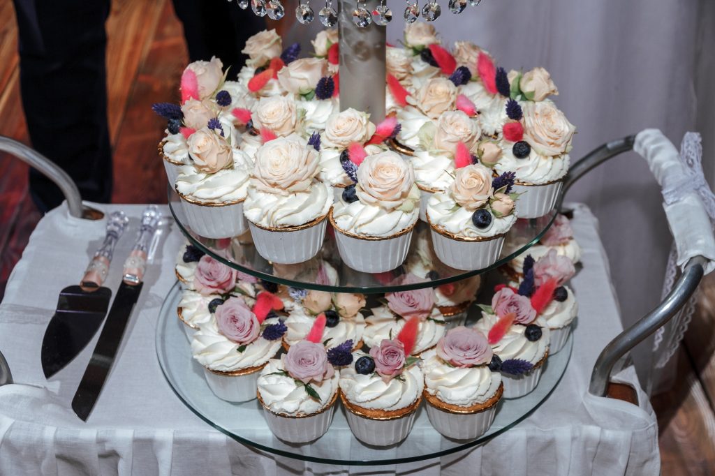Wedding white cupcakes on a glass stand.